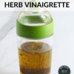 layered ingredients for herb vinaigrette in shaker jar.