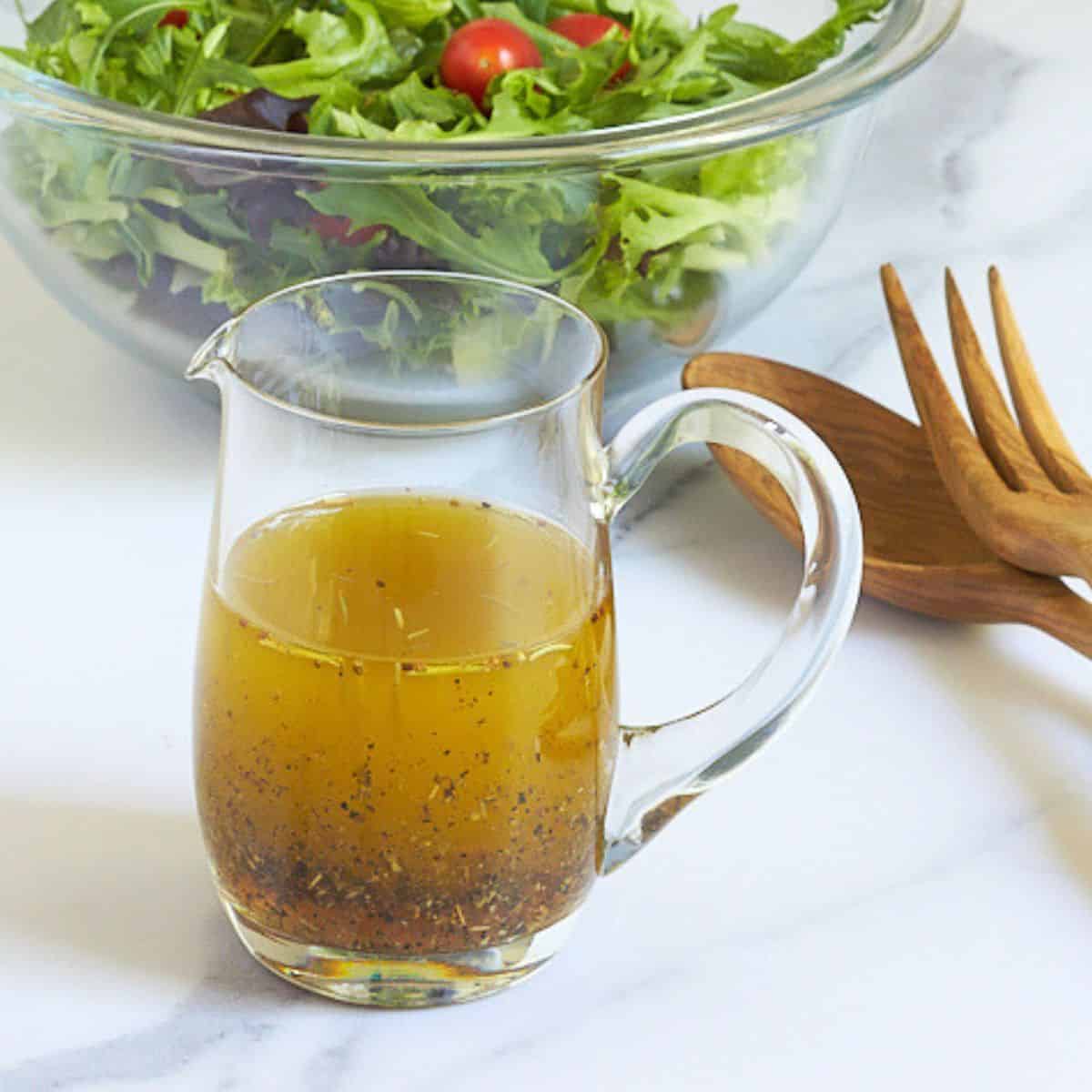 herb vinaigrette in a small, clear glass pitcher.