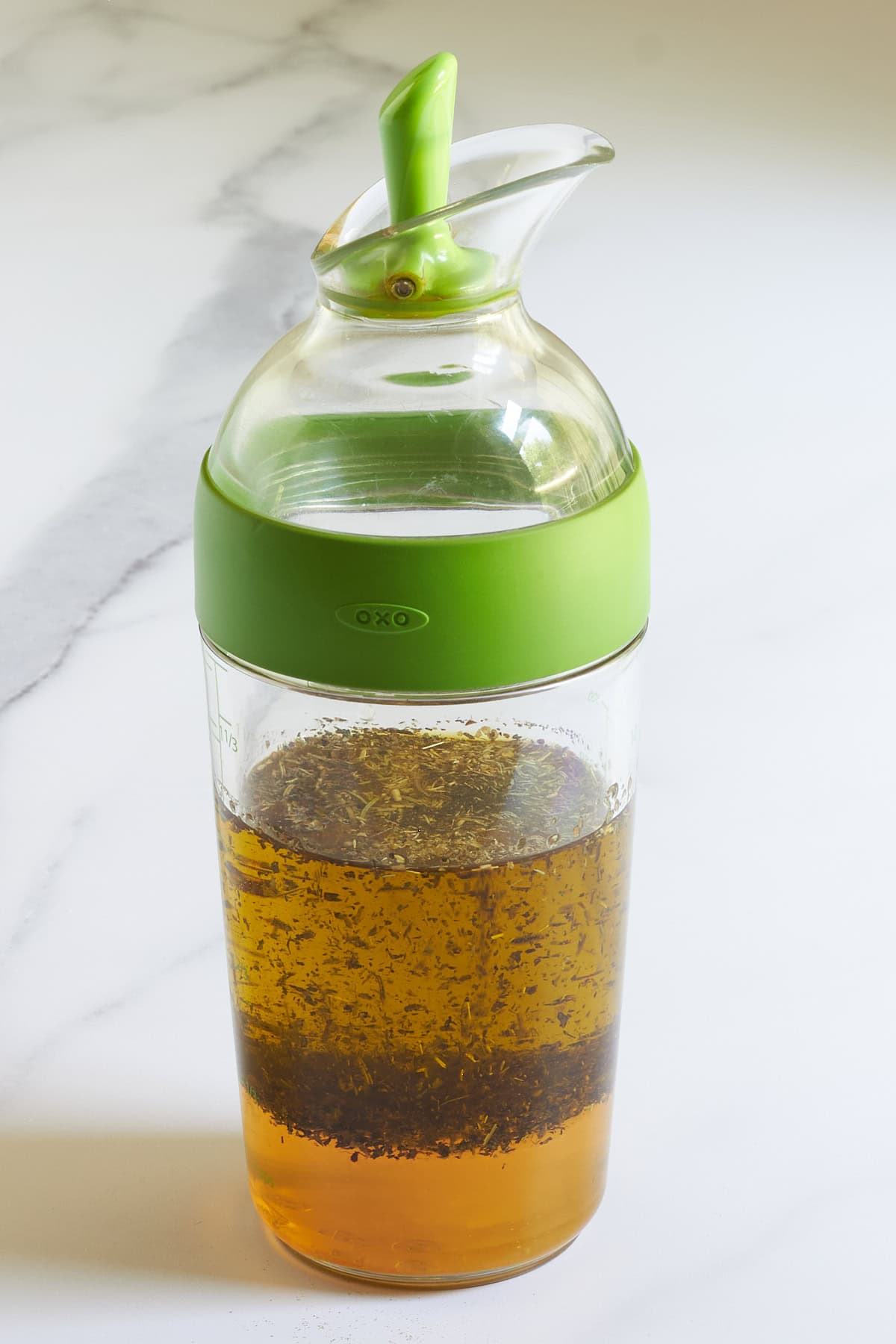herb vinaigrette in Oxo jar with lime green lid.
