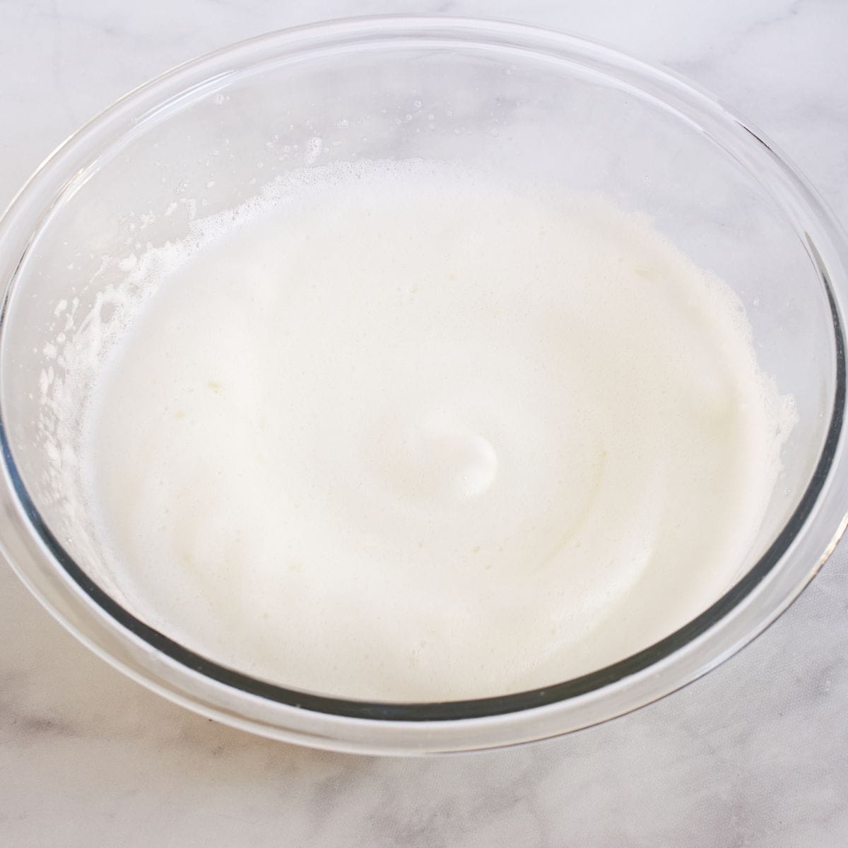 stiffly beaten egg whites in glass bowl.