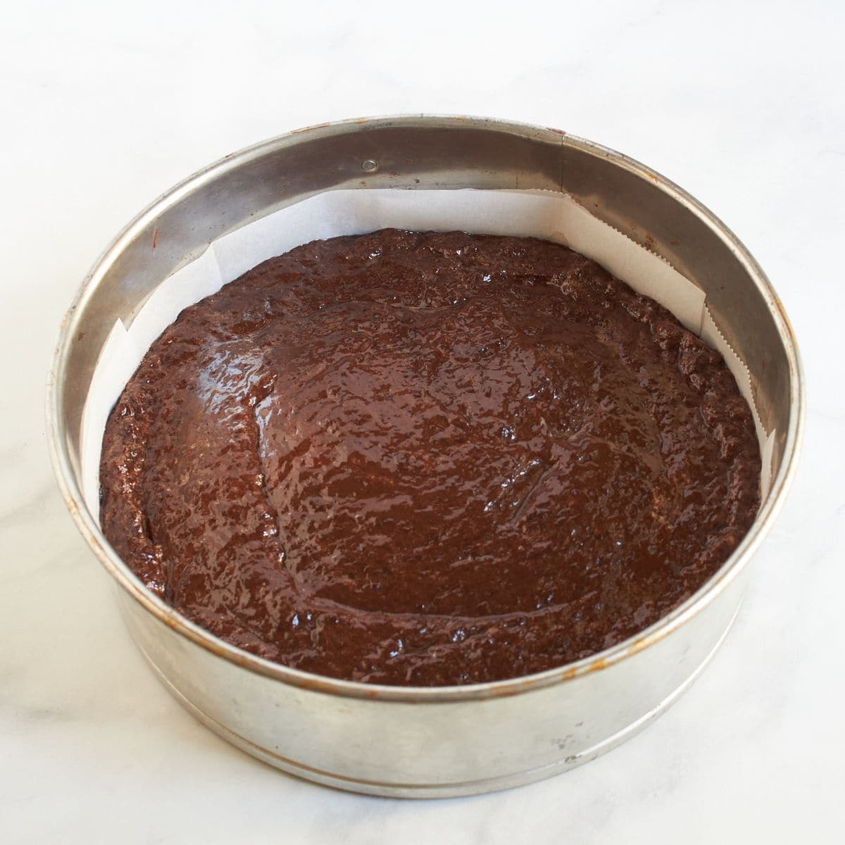 chocolate cake batter in lined springform pan.