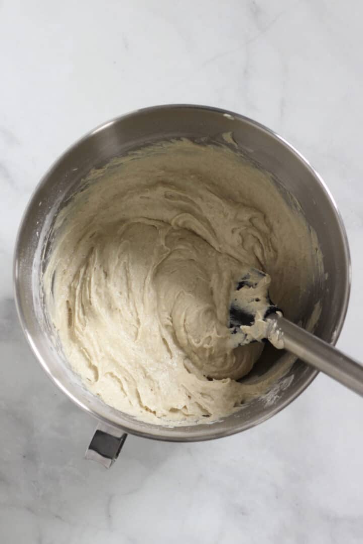 pale batter stirred in a mixing bowl with a spatula.