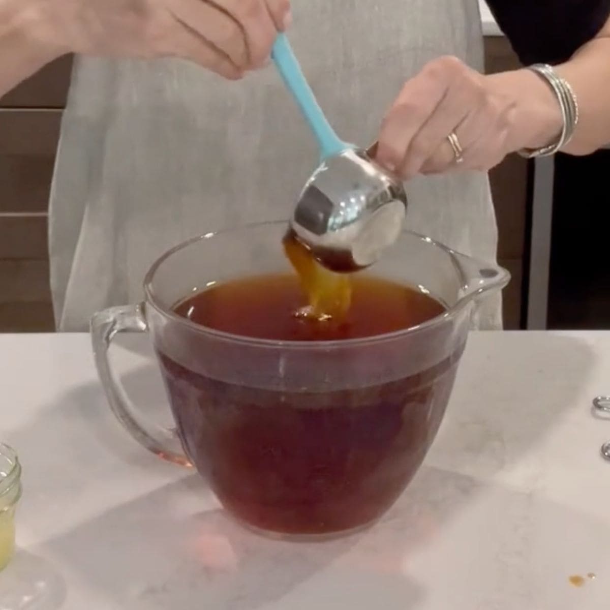 honey pouring into steeped tea.