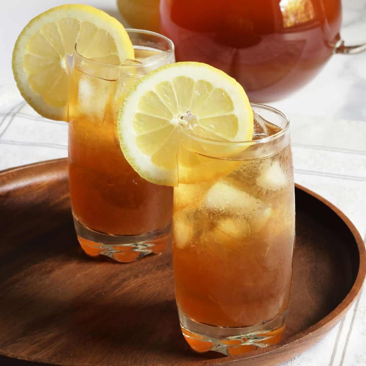 two glasses of iced tea garnished with lemon slices.