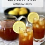 two glasses of tea with ice cubes and lemon slice in front of clear teapot and bowl of lemons.
