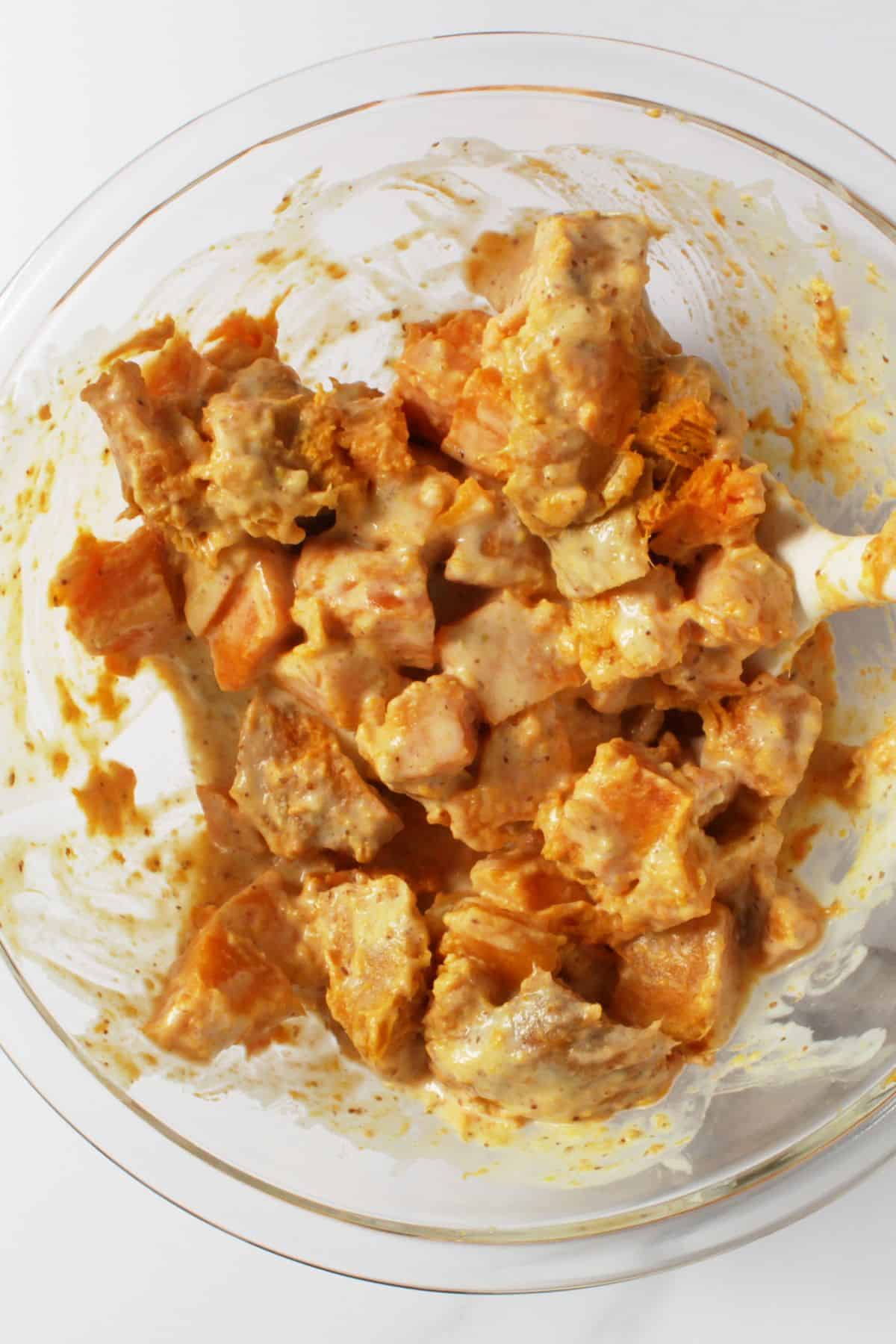 chopped, cooked sweet potatoes and bacon coated with dressing.