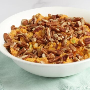 sweet potato salad with bacon and pecans in white bowl.
