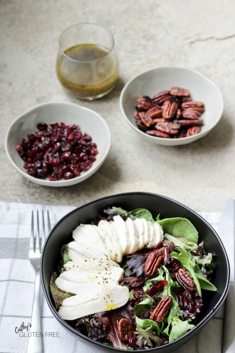 sliced chicken on lettuce with cranberries, candied pecans, and poppyseed dressing