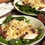 shredded cheese over chopped bacon, fried egg, and spinach.