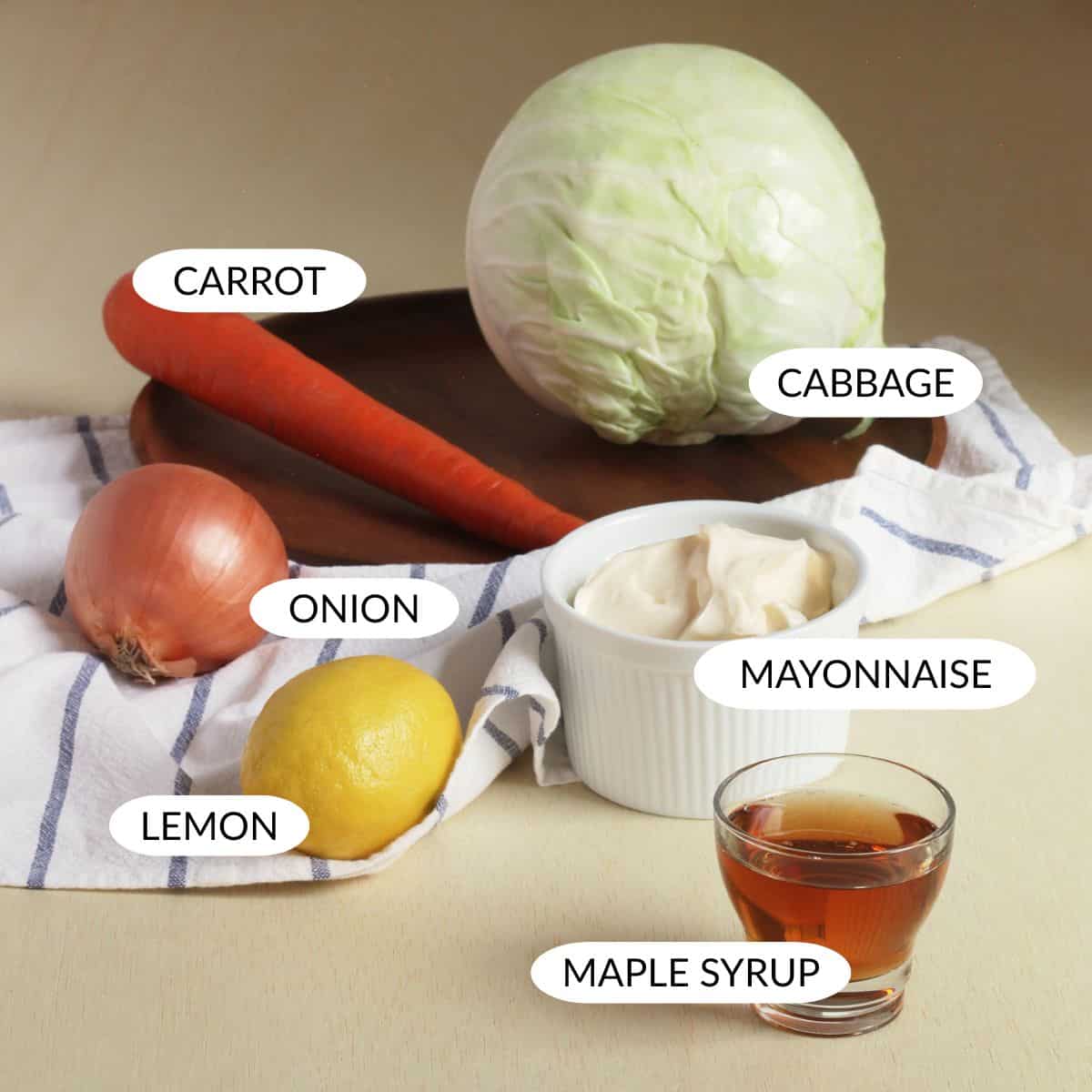 whole cabbage, onion, lemon, mayonnaise, and maple syrup with labels.