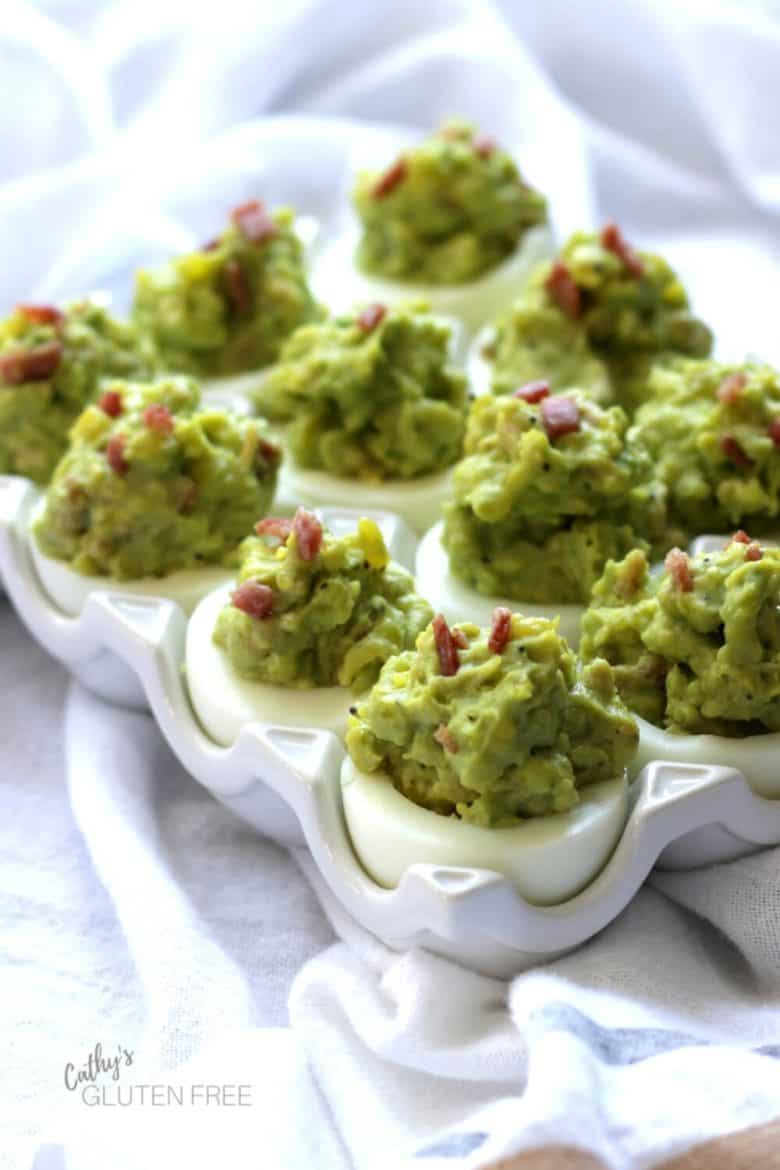 Deviled eggs with bacon and avocado garnished with bits of bacon
