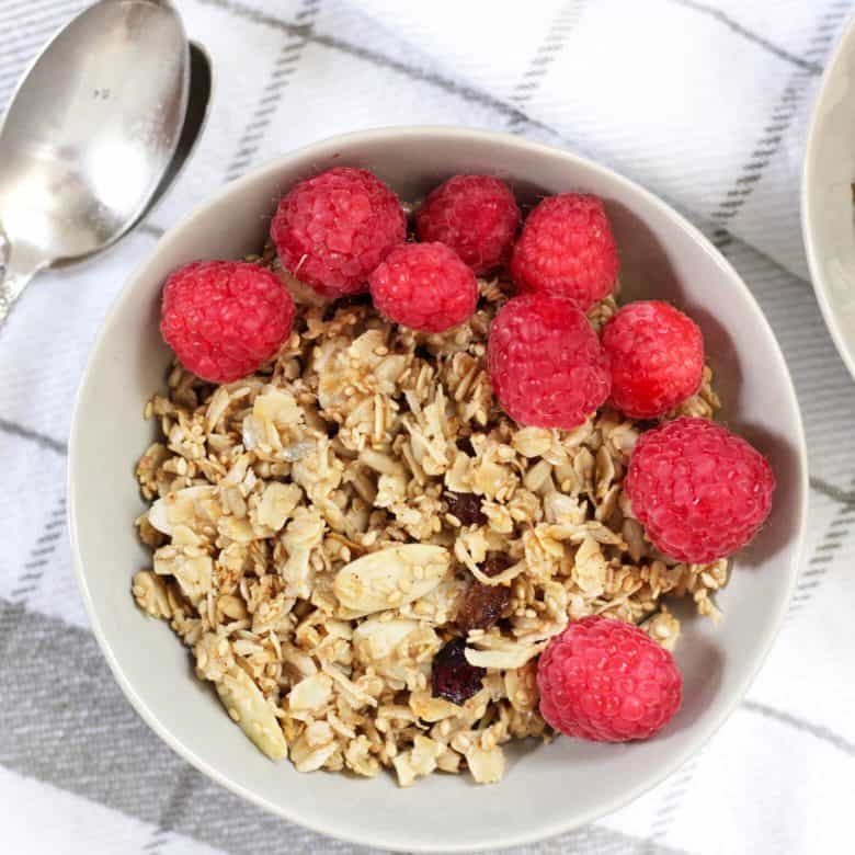 looking down on a bowl of granola topped with raspberries