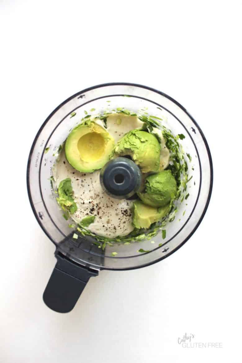 avocado, cashew yogurt, and herbs in food processor bowl