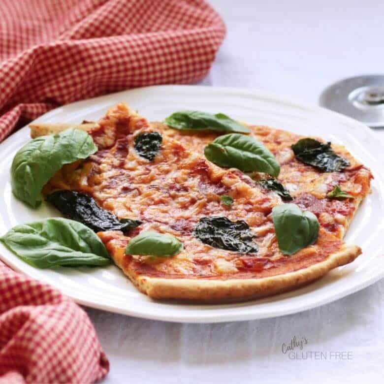 two slices of pizza topped with tomato sauce, cheese, and basil served on a white plate