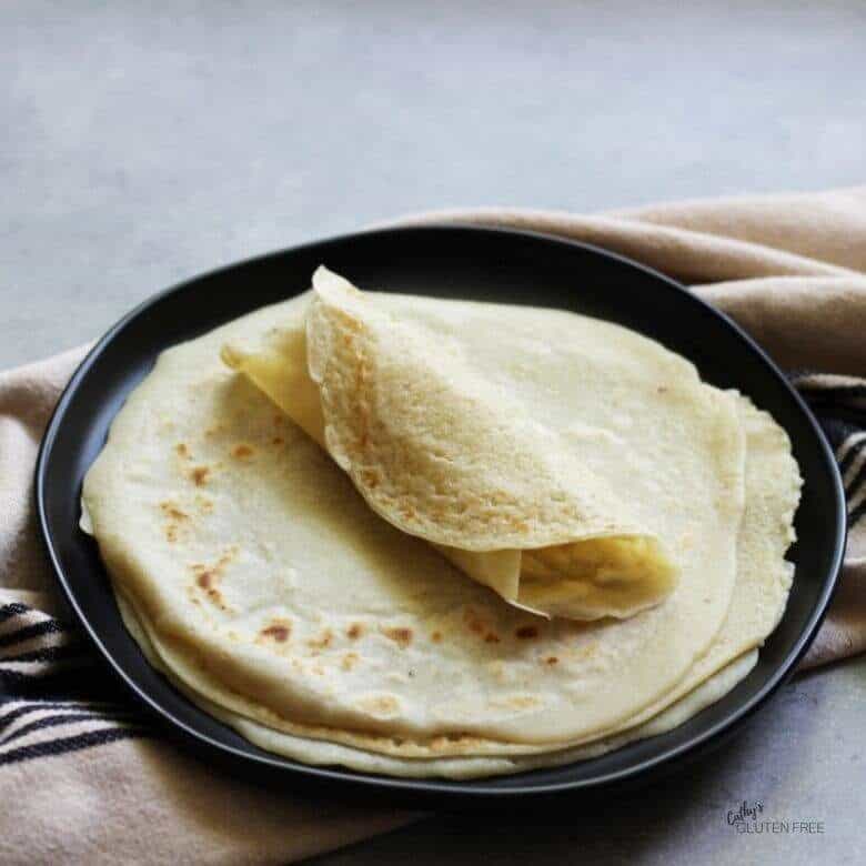 gluten free tortillas stacked on black plate