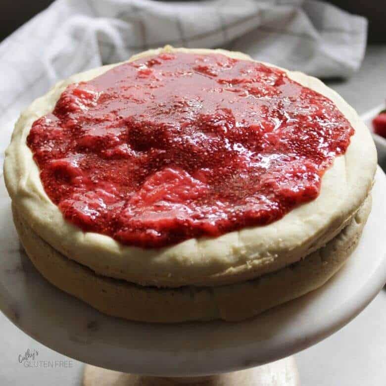 strawberry jam spread over the top layer of cake