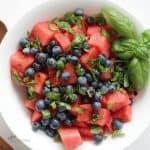 overhead view of watermelon salad with blueberries and basil