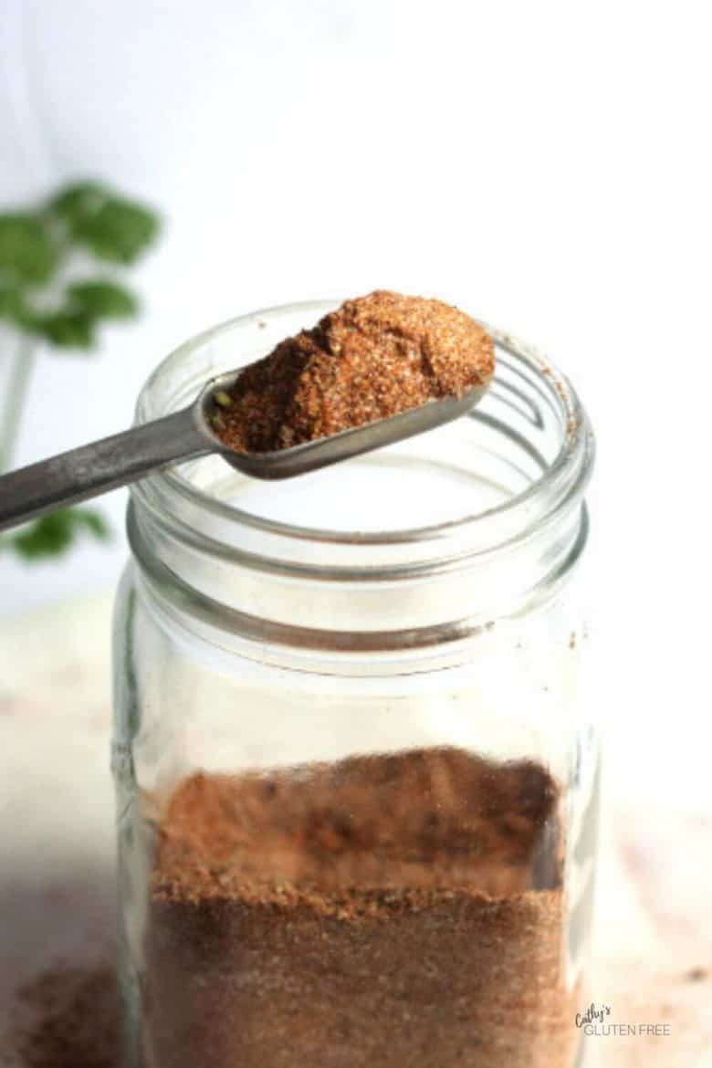 homemade taco seasoning mix being scooped from jar