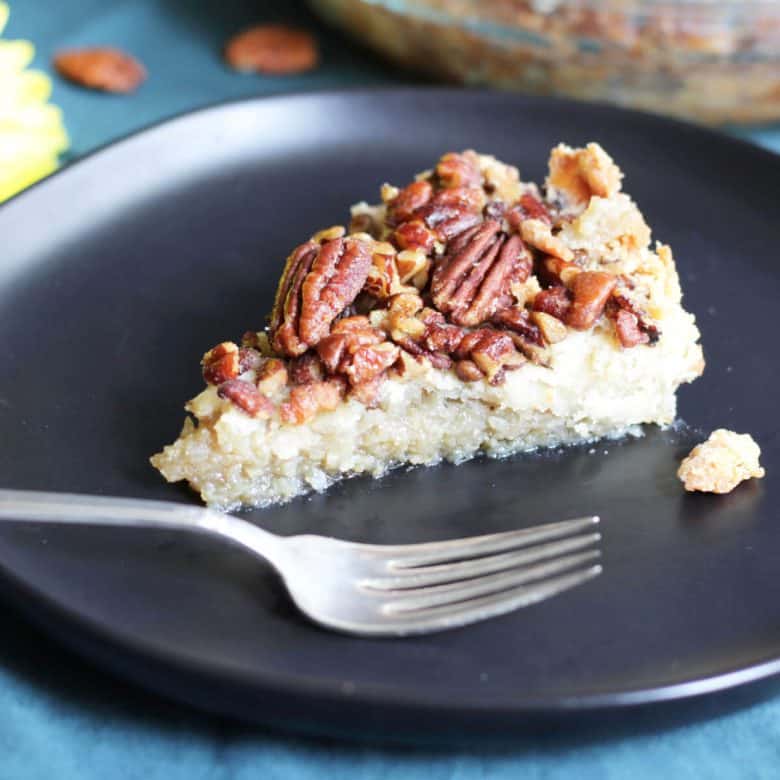 slice of pecan pie on black plate with silver fork