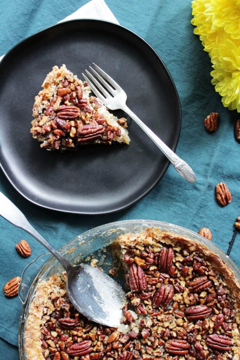 pecan pie with a slice served on a black plate