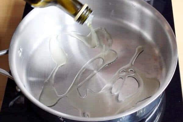 oil is drizzled into stainless steel pan