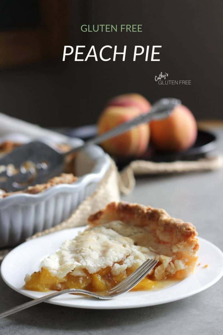 slice of peach pie on white plate with fresh peaches in background