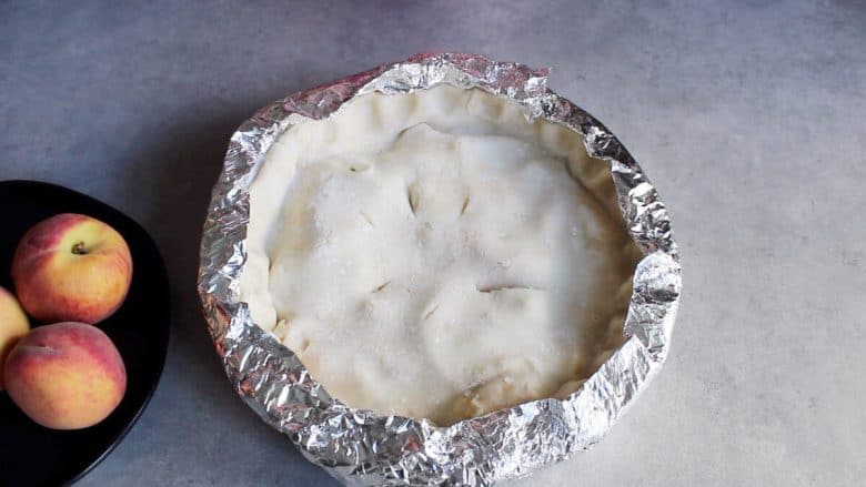 unbaked pie with foil collar covering the edges