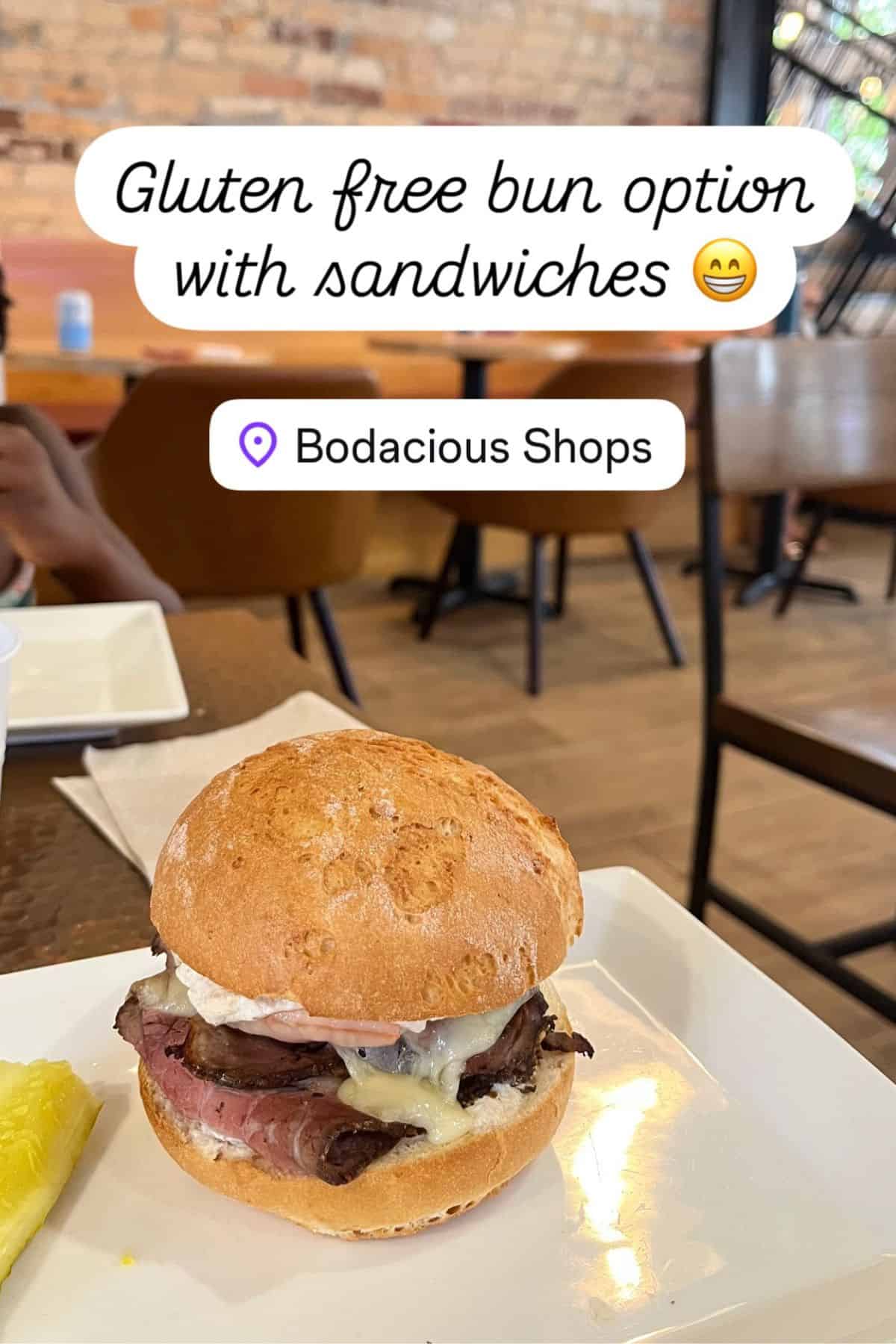 sandwich on a bun in cafe setting with brick wall.