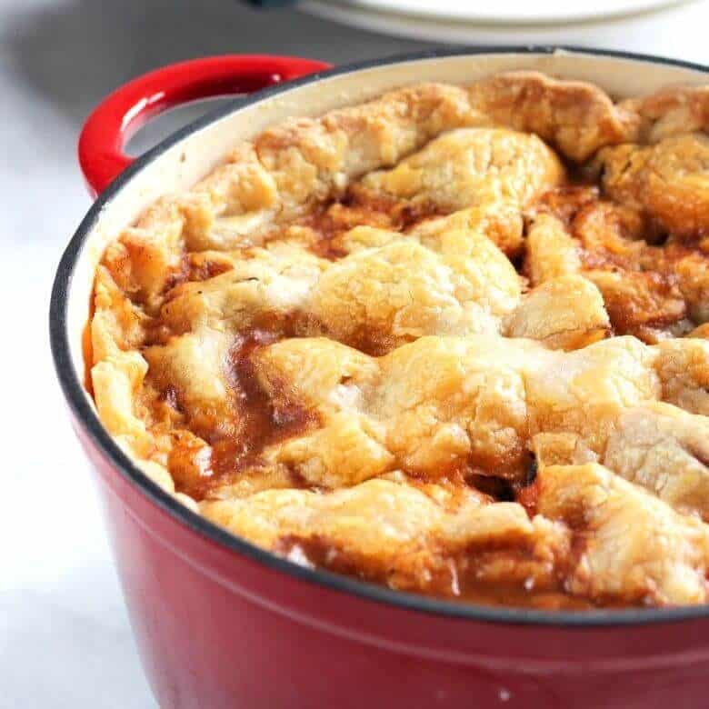 golden pie crust topping a full, red Dutch oven