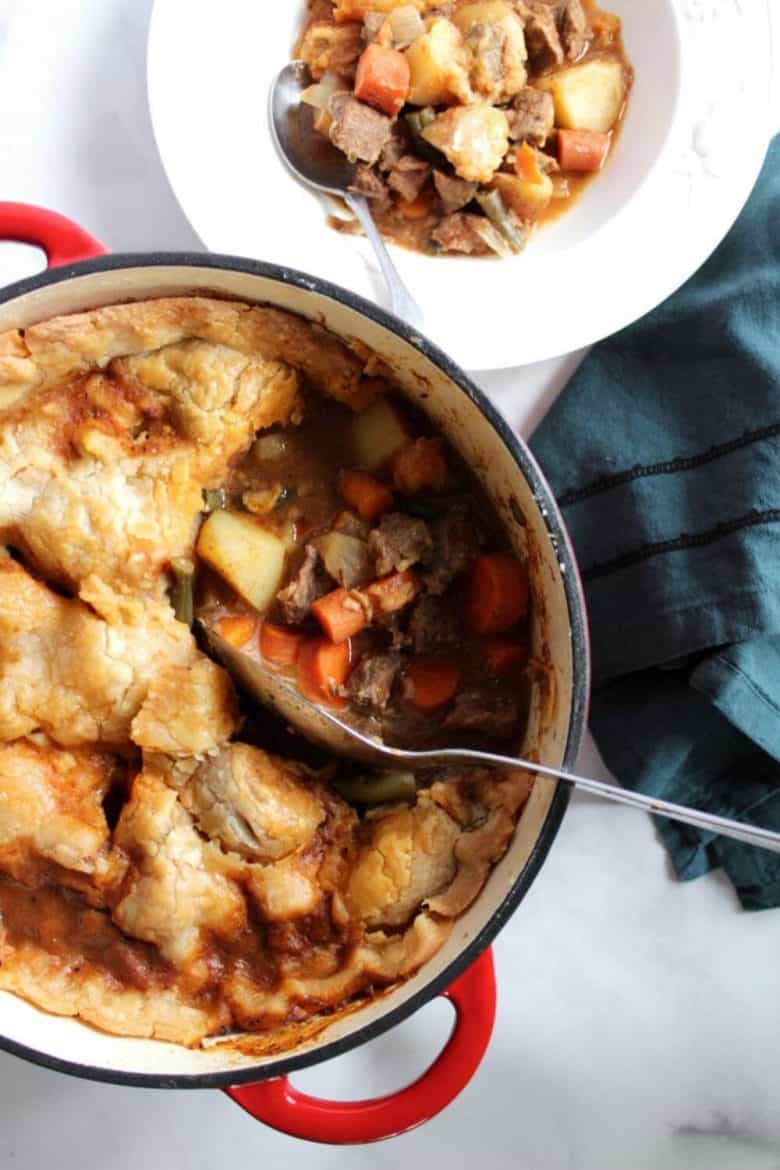 top down view of pot pie with a serving scooped into white bowl