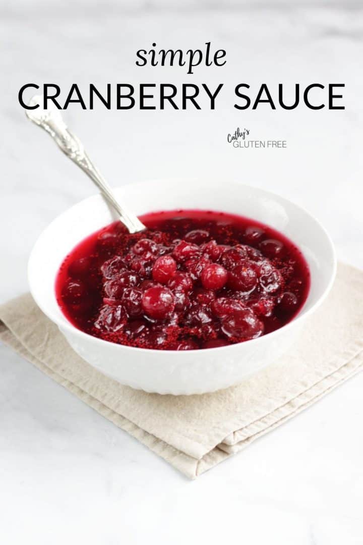 Simple cranberry sauce in white bowl on linen napkin with silver spoon