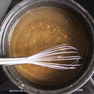 whisk resting in gravy in roasting pan