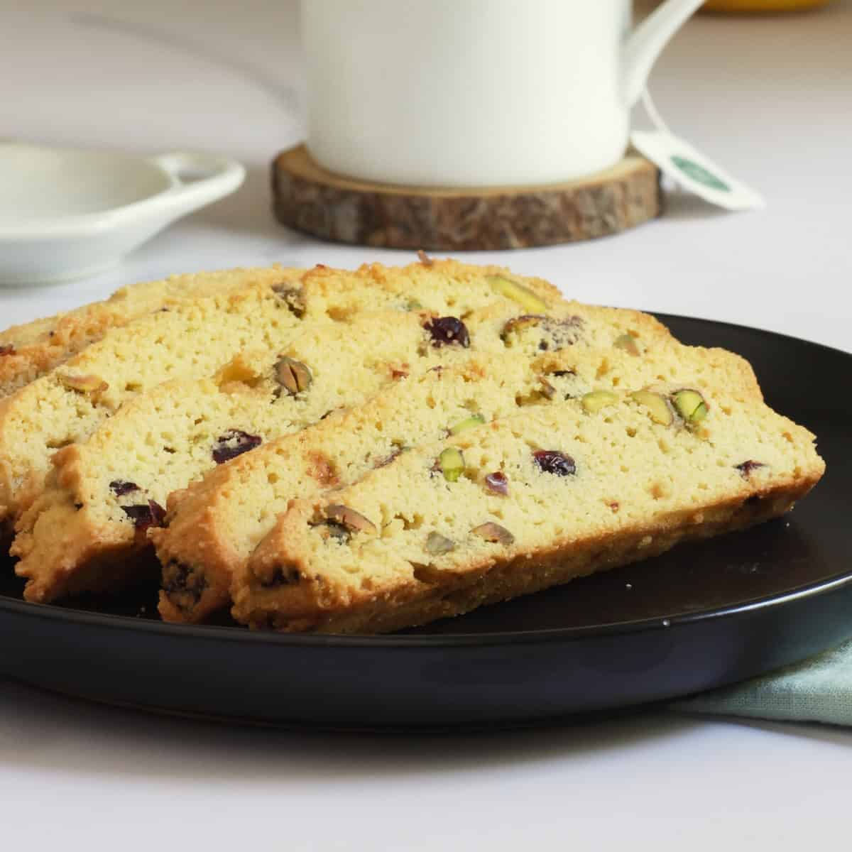 closeup of gluten-free cranberry pistachio biscotti on black plate