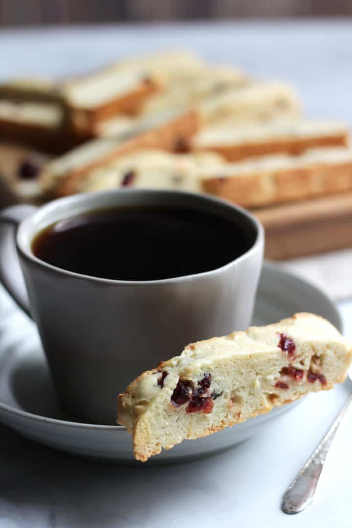 cranberry almond biscotti with coffee and more biscotti scattered in background