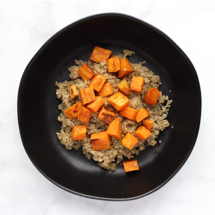 sweet potatoes chunks on quinoa in black bowl