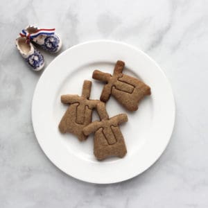 3 windmill cookies on white plate, ceramic "wooden" shoes to side