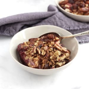 bowl of baked oatmeal with raisins and pecans on top