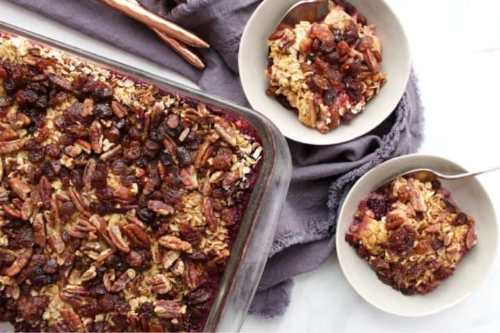 top down view of oatmeal, pecans, and raisins casserole in two bowls and a pan