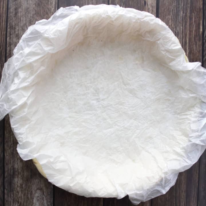 parchment paper spread over and pressed into unbaked pie shell