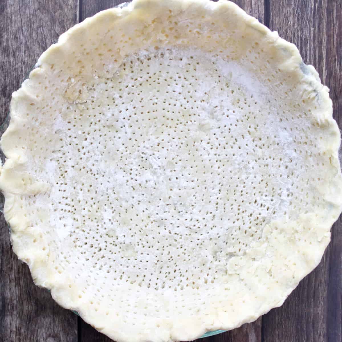 pie plate lined with unbaked pastry pricked all over with little holes