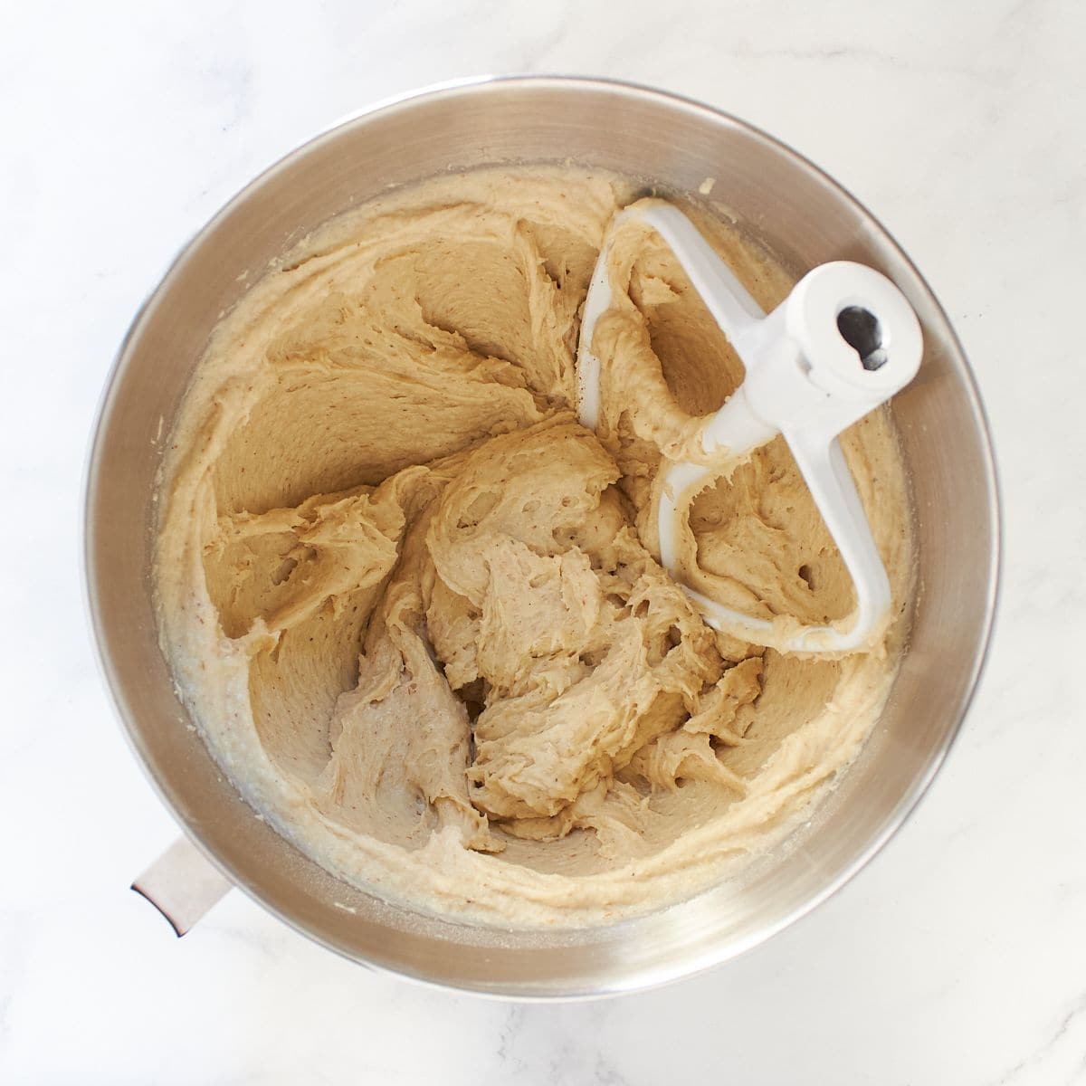 soft batter in bowl of stand mixer with mixing paddle.