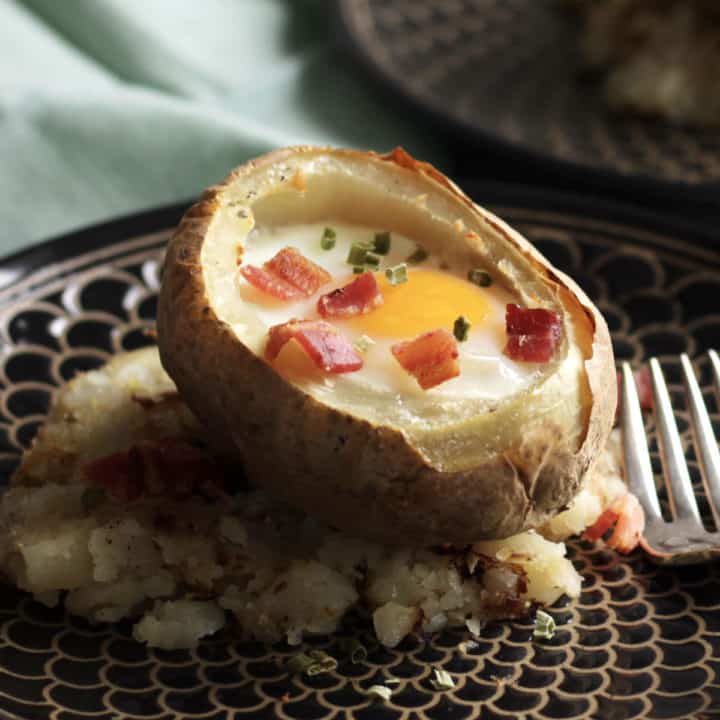 baked breakfast potato with egg garnished with chopped bacon and chives