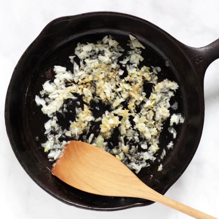 chopped onion frying in a cast iron skillet