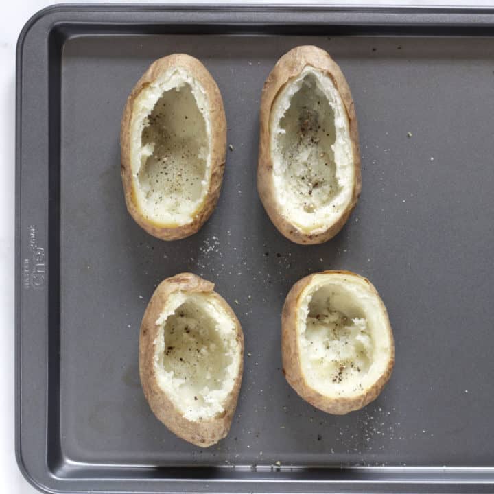 scooped out baked potato shells on baking tray