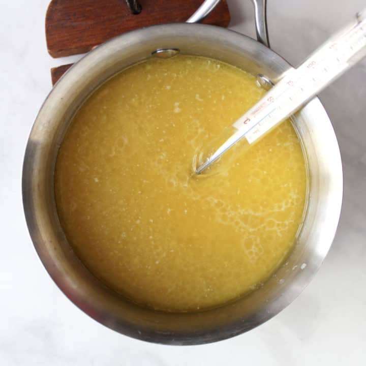 melted butter and milk in saucepan with thermometer