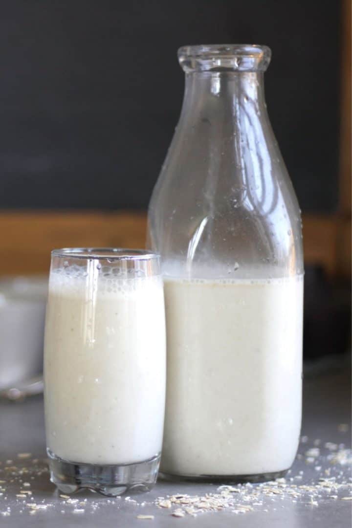 glass of milk standing beside a half-full milk bottle