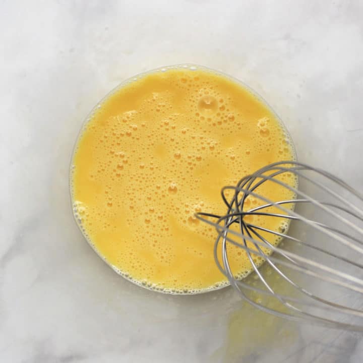 whisked eggs in glass bowl