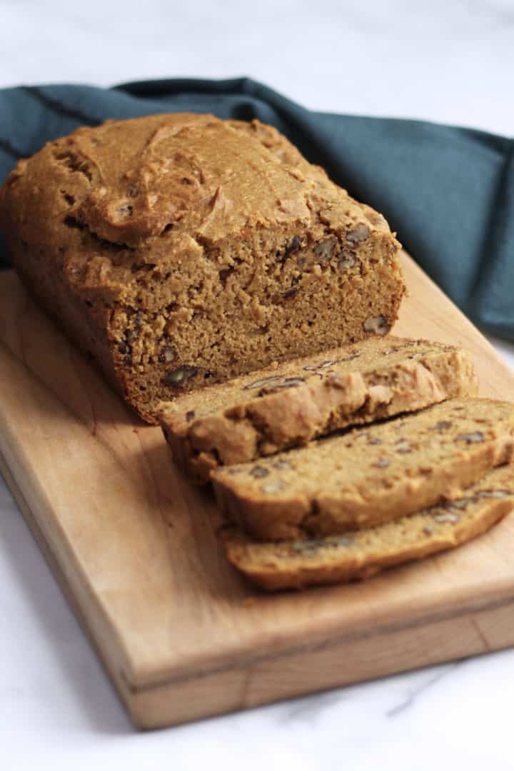 partially-sliced gluten free sweet potato loaf on wooden board