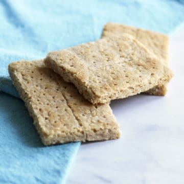 three gluten free graham crackers on a turquoise napkin, viewed from an angle