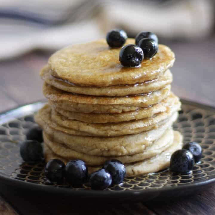 stack of pancakes with blueberries and syrup on top